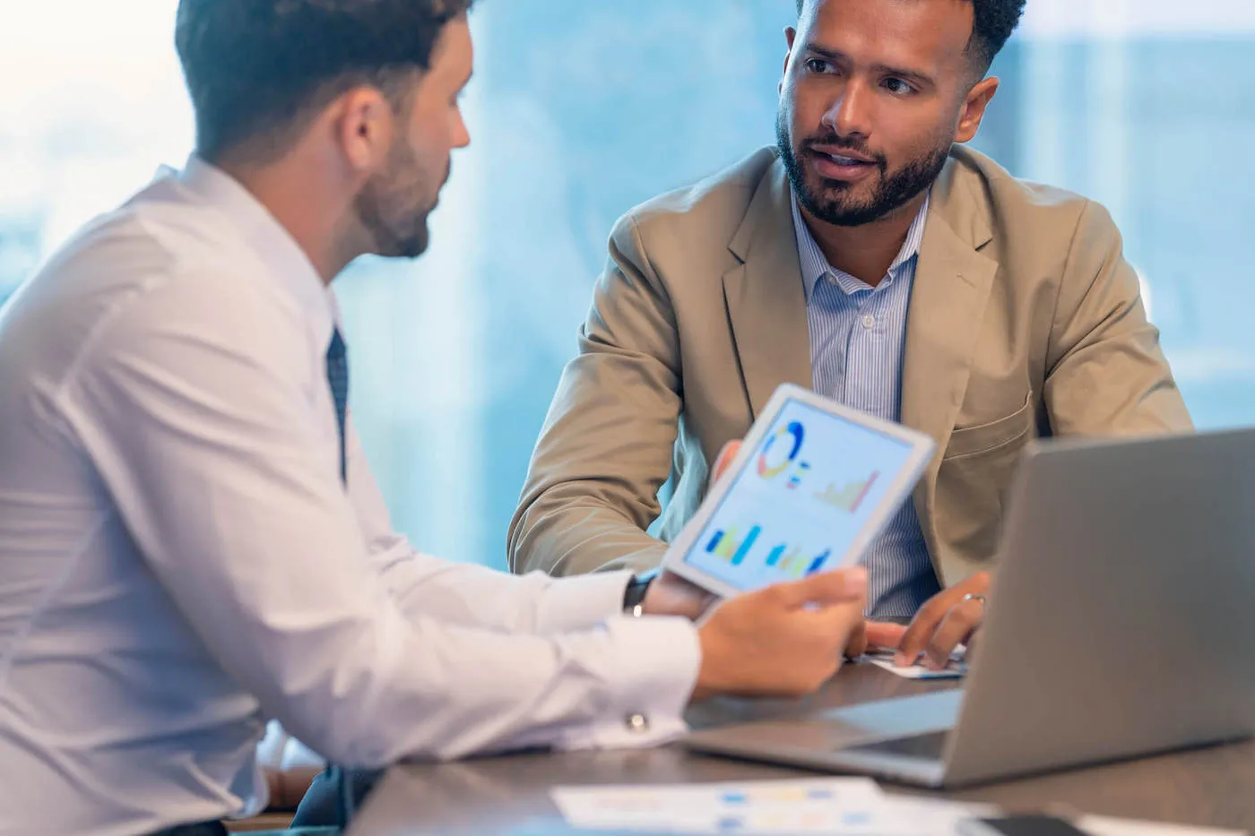 Two men in a meeting about valuation coverage.