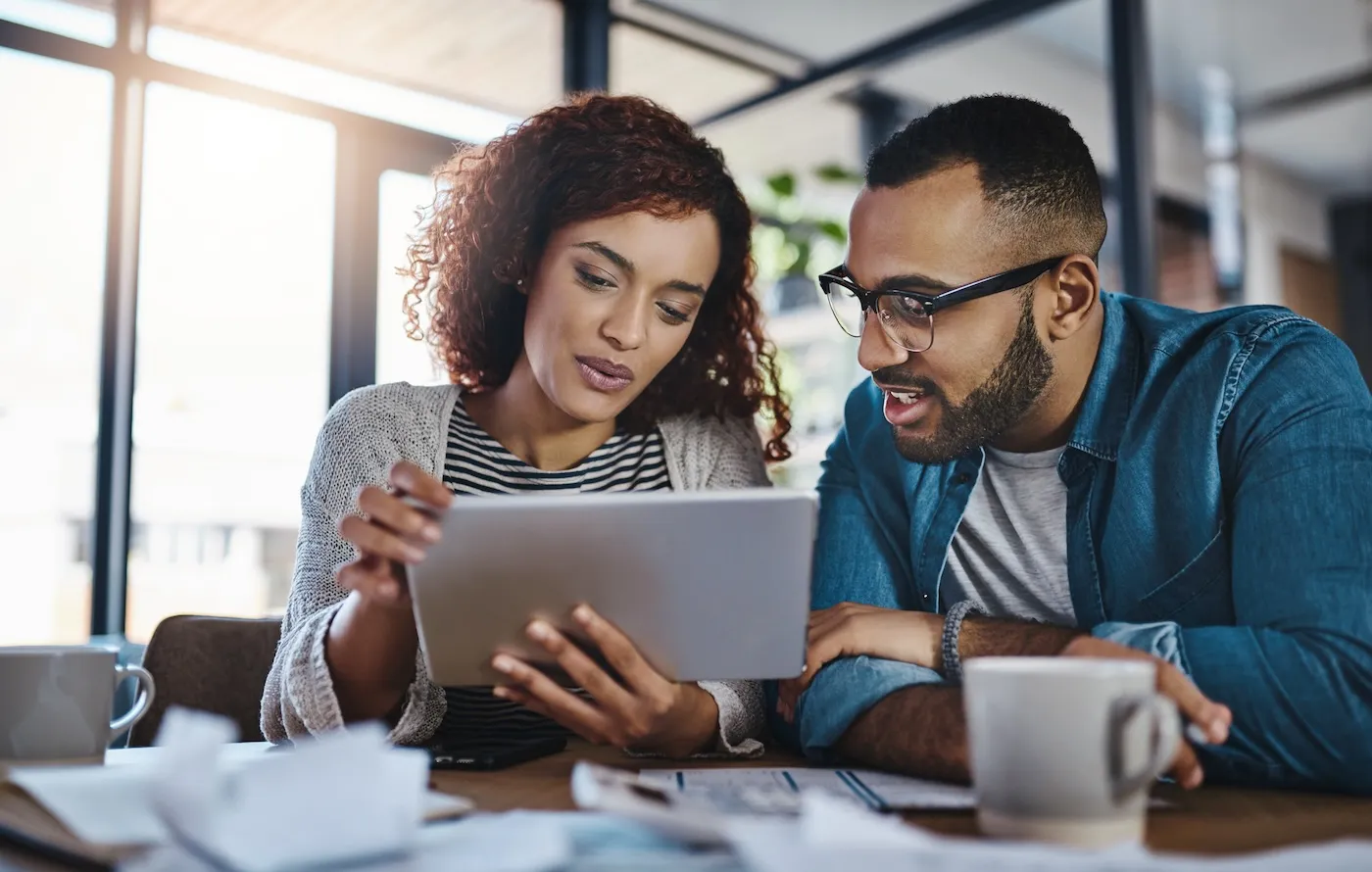 Shot of a young couple using a digital tablet while planning their budget together at home