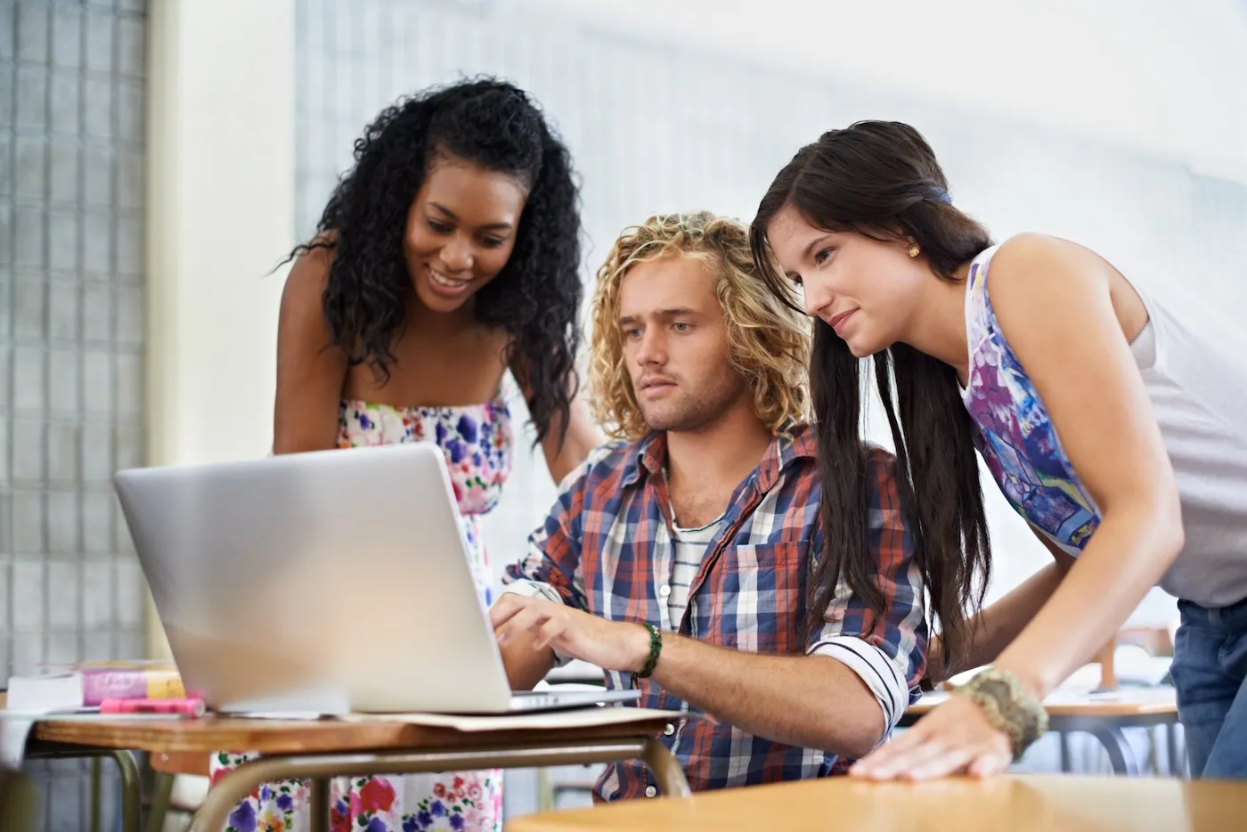 A group of students looking at a laptop, learning about building credit.