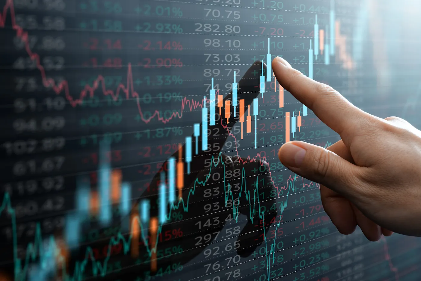 Candlestick chart and finger pointing to data of investments.