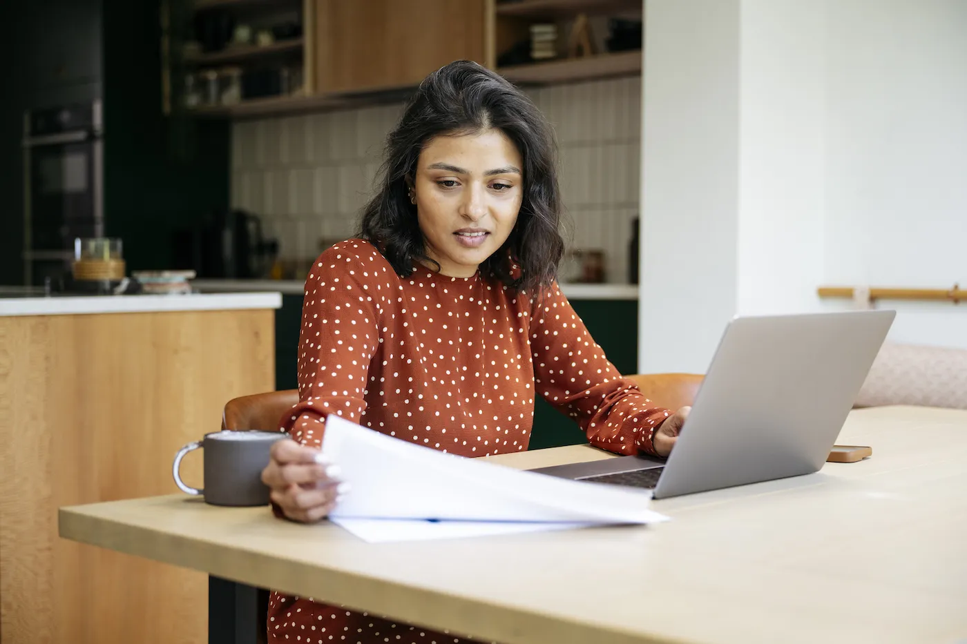 Distressed woman reviewing papers and laptop