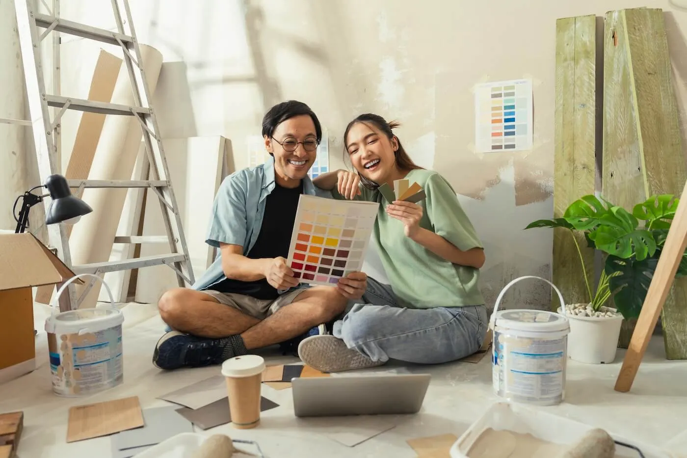 A smiling young couple choosing the wall color for their living room