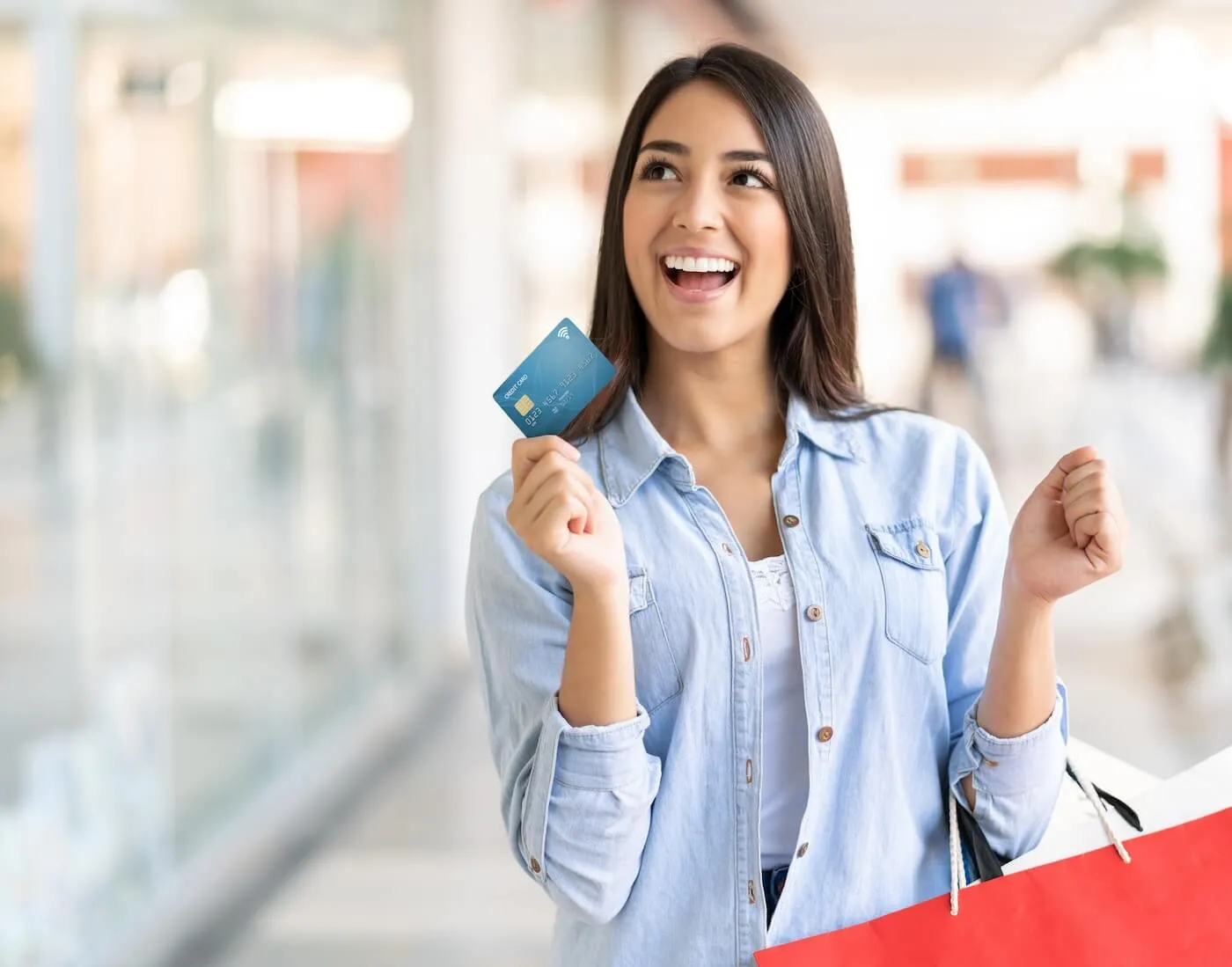 A happy woman holding a credit card