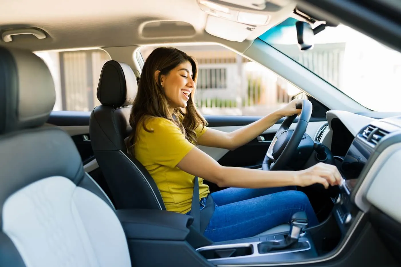 Smiling young woman adjusting fan in her car