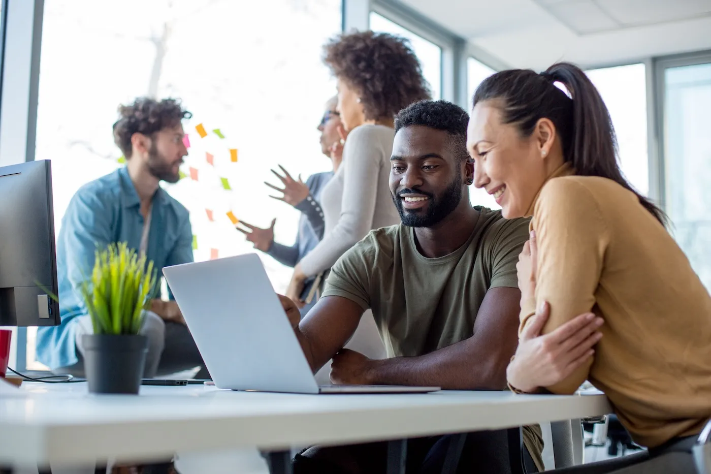 Two colleagues discussing finance while looking at a laptop