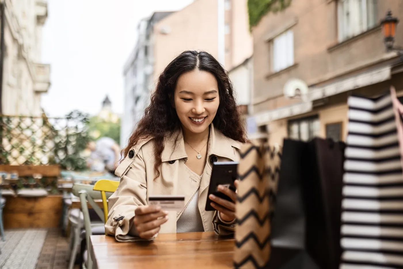 Young woman in cafe using credit card for online shopping