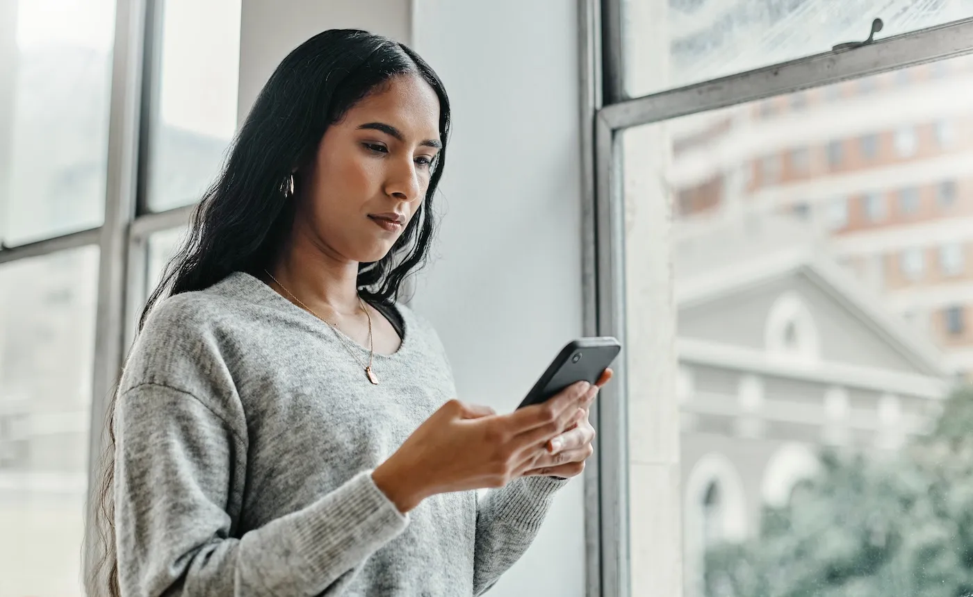 A woman checking her credit report on her phone.