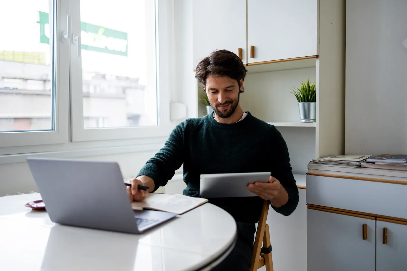 Man living abroad using digital tablet and computer.