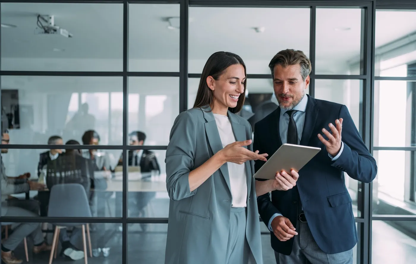 Shot of two coworkers having a discussion about banking in modern office.