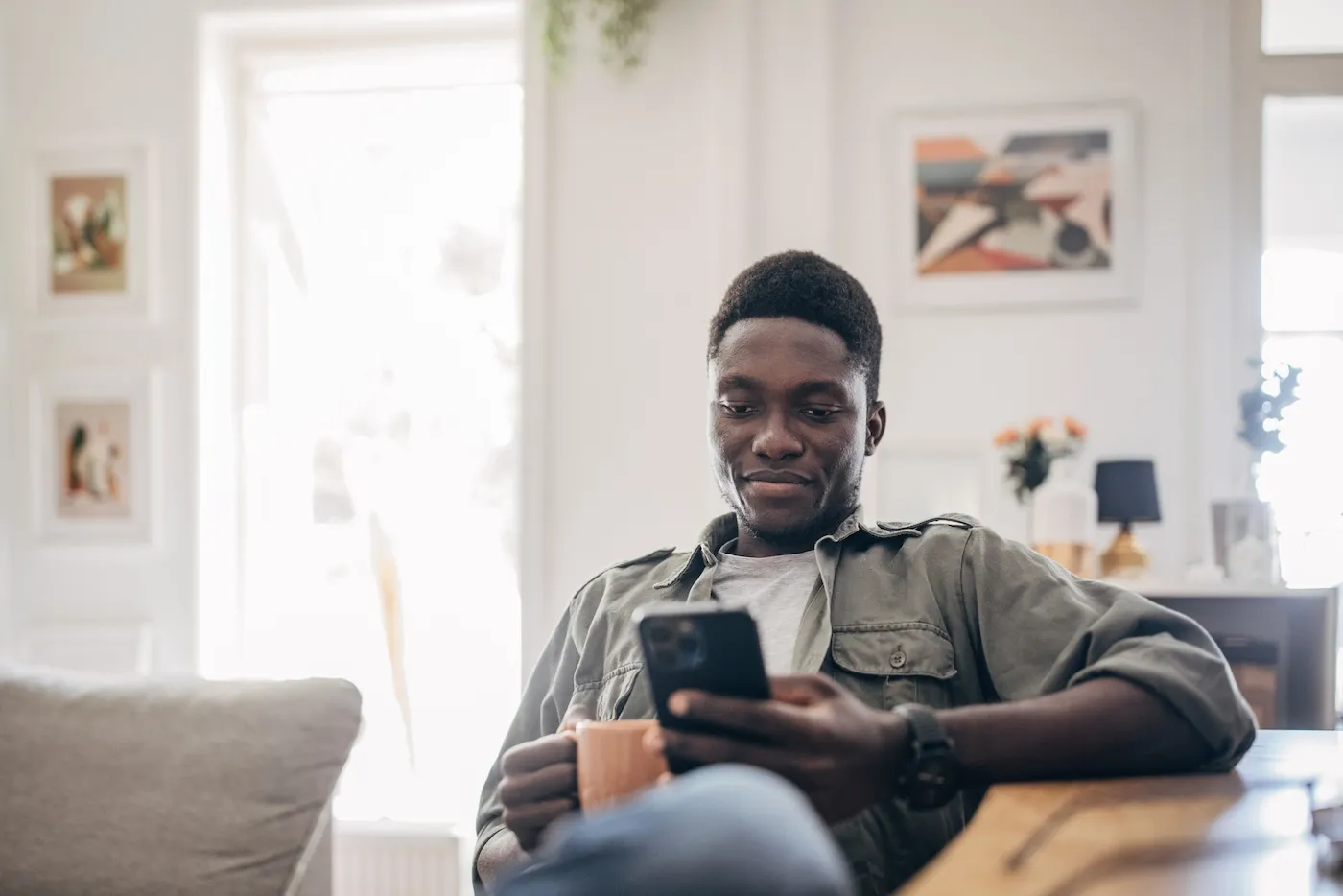 Young man relaxing at home and using mobile phone