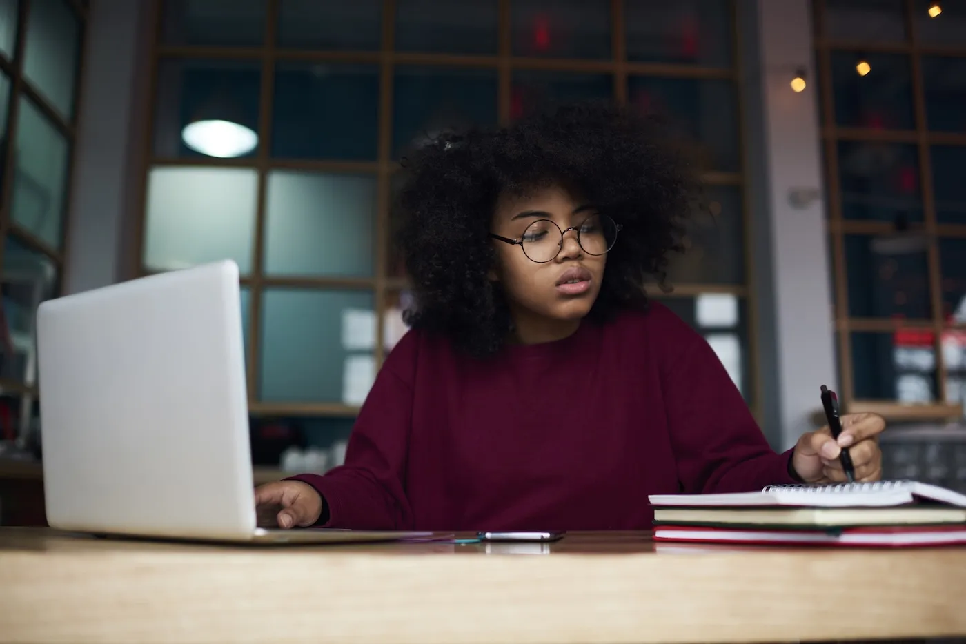 Concentrated young woman in glasses learning.