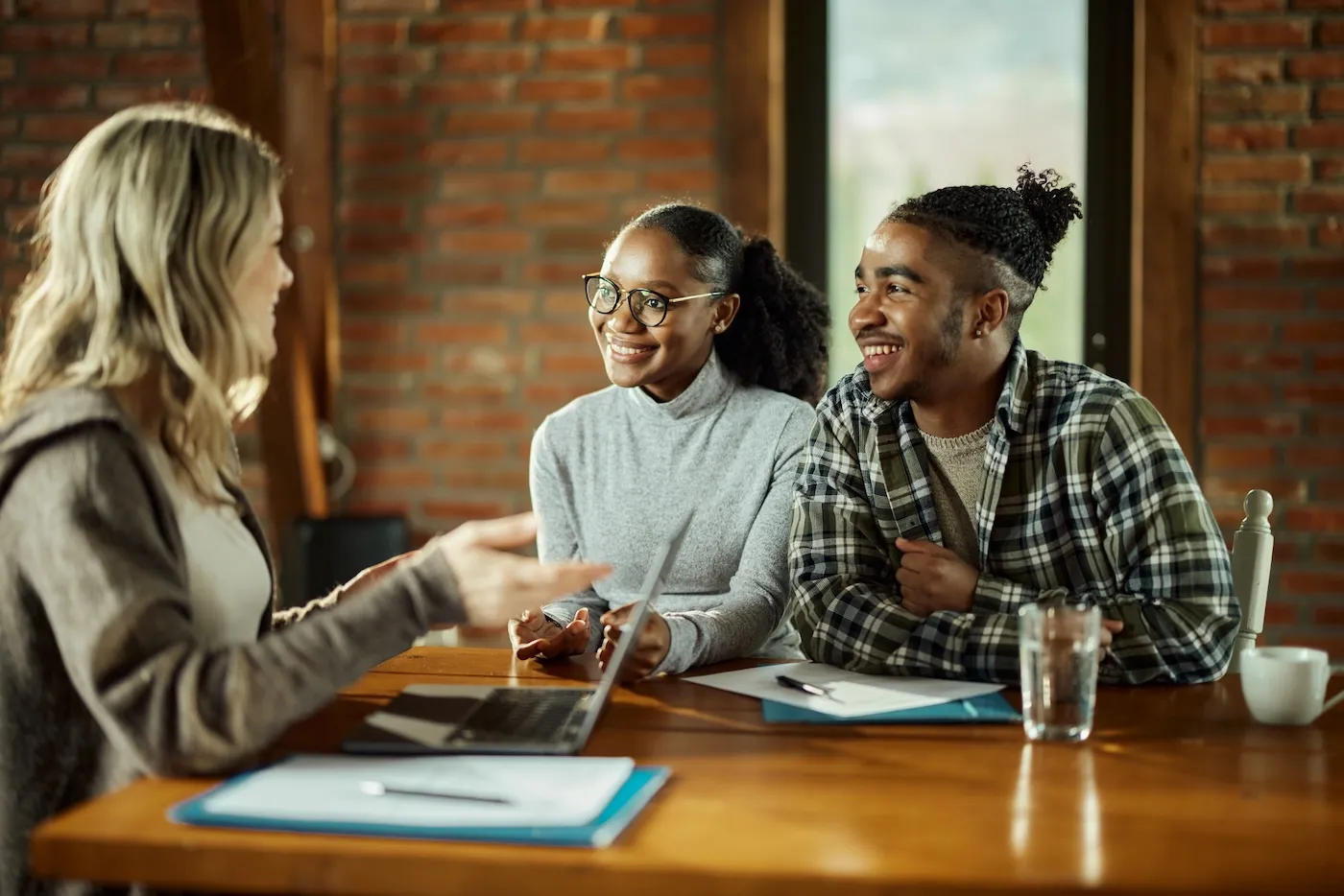 A couple communicating with their life insurance agent during a meeting in the office.