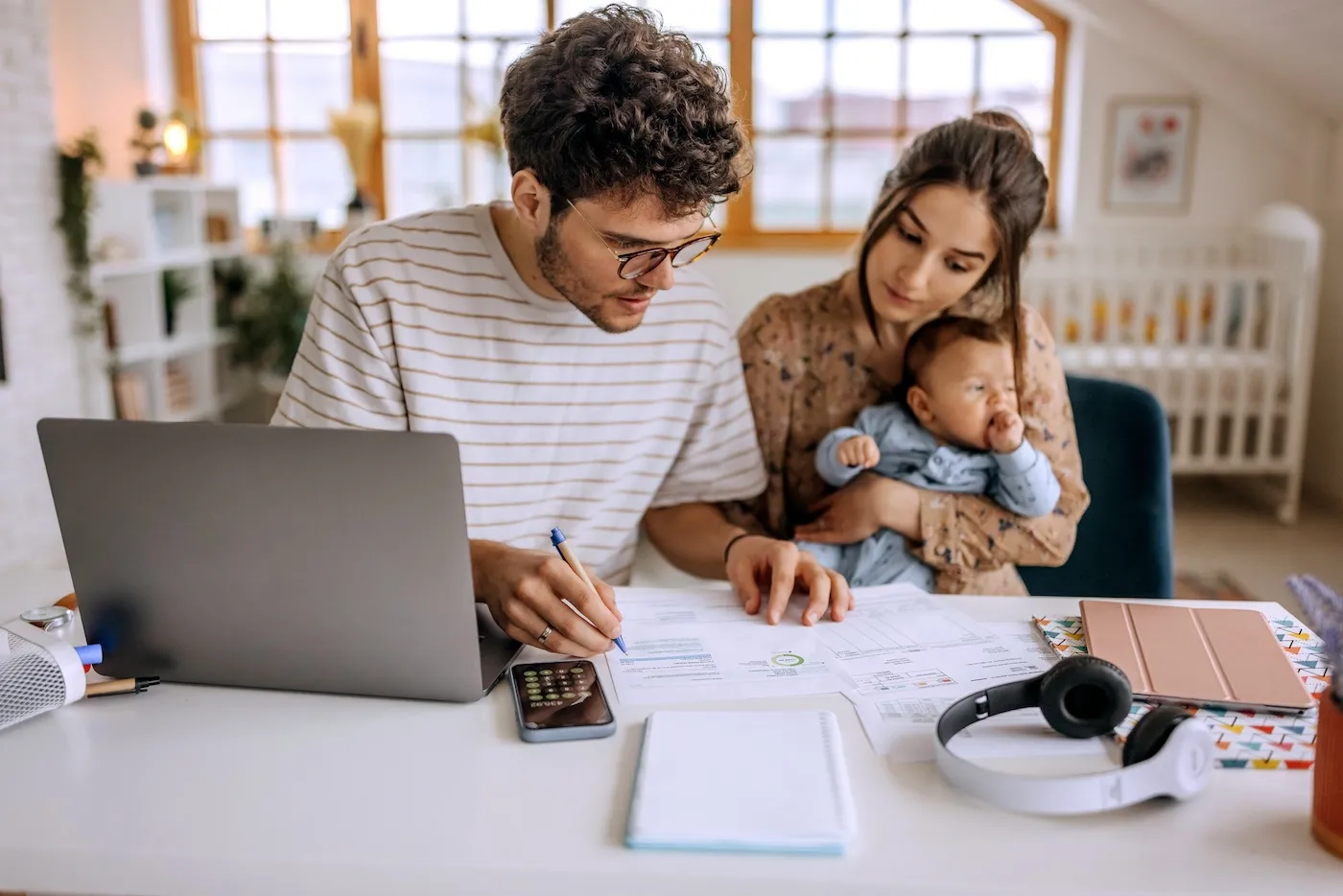 Young family with cute little baby boy going over finances at home