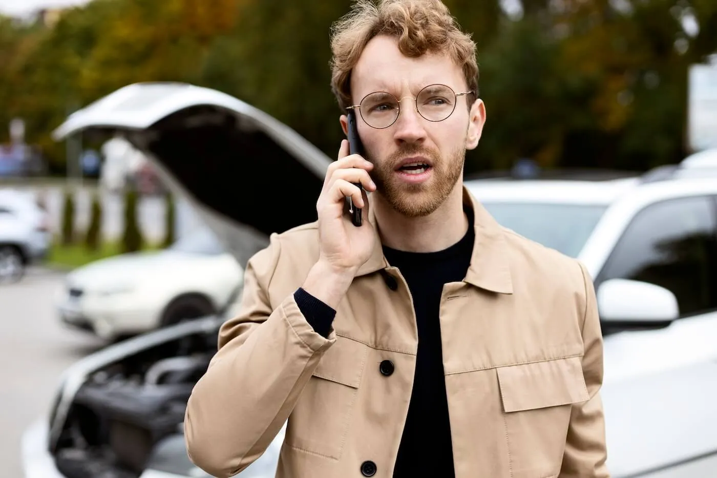 Concerned young man making a phone call after a minor car accident