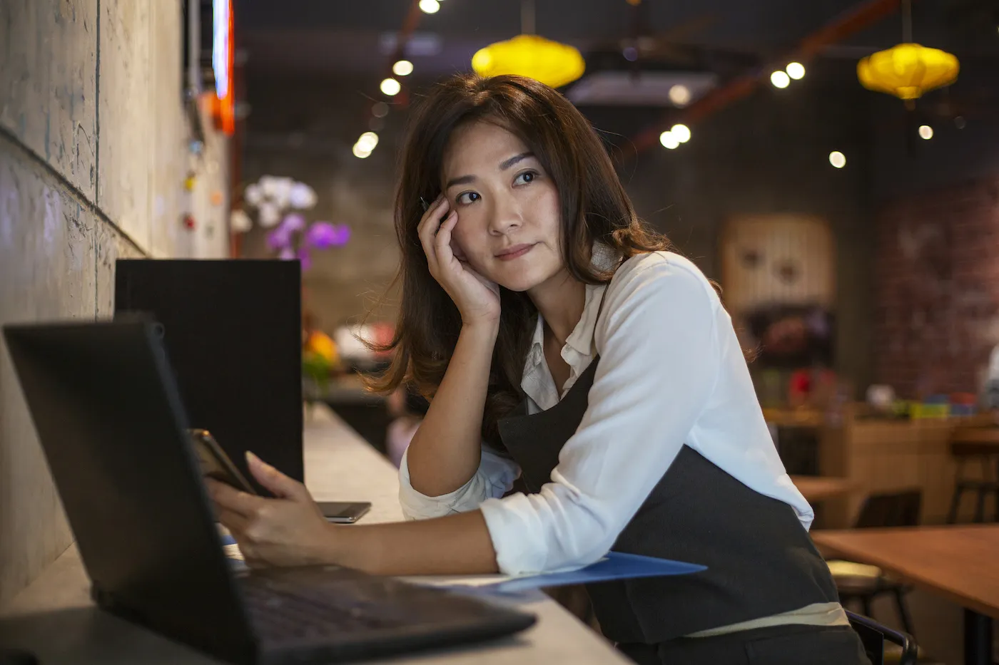 A worried business owner considering where to put her savings during a recession.