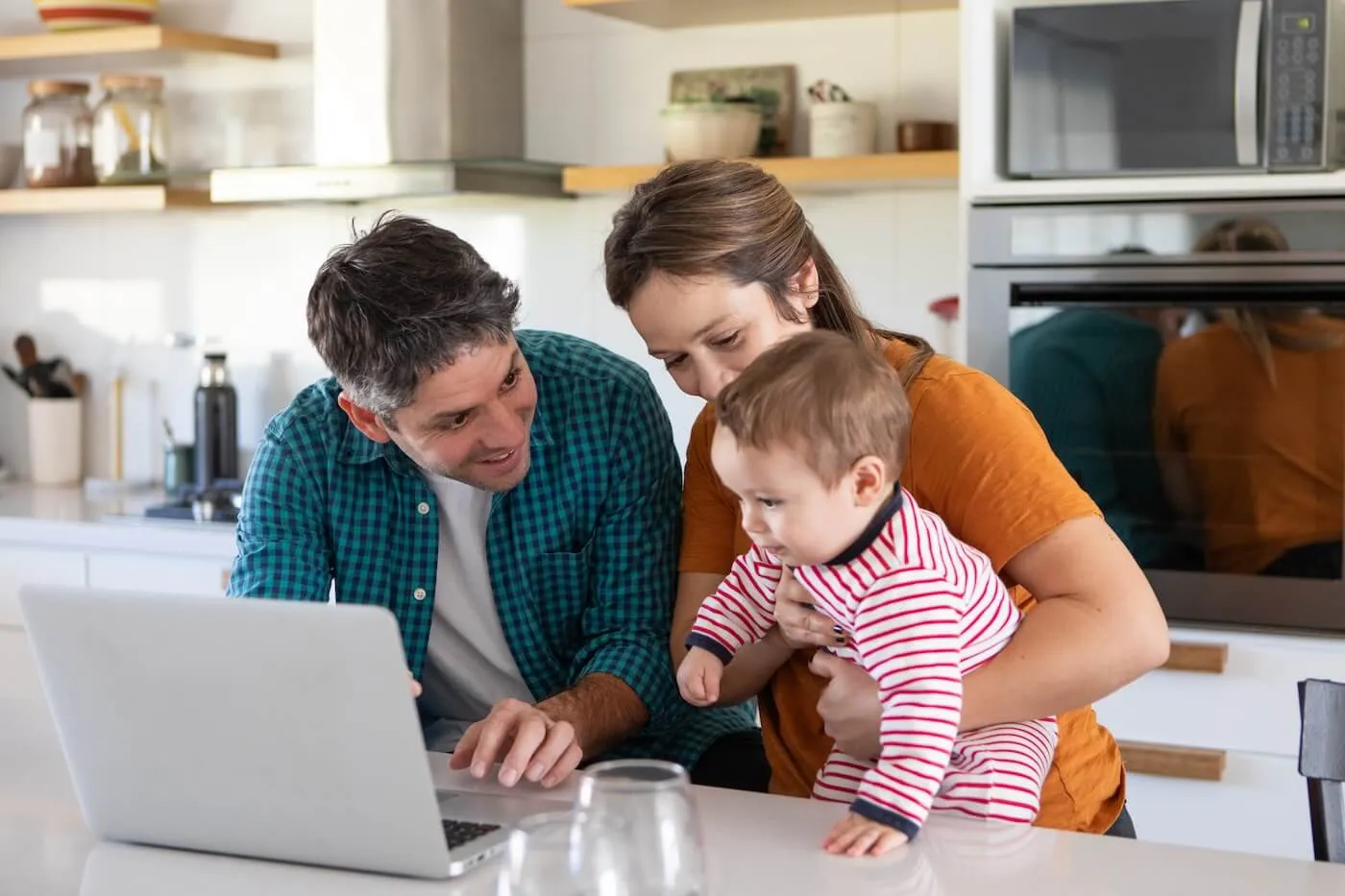 Happy family of three using a laptop