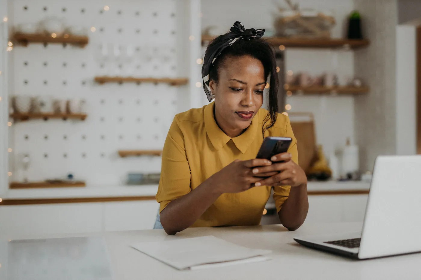 Young woman checking her credit using her smartphone at home