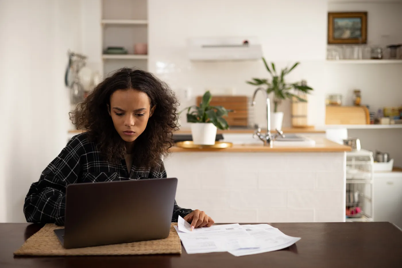 A woman going over insurance paperwork on her laptop