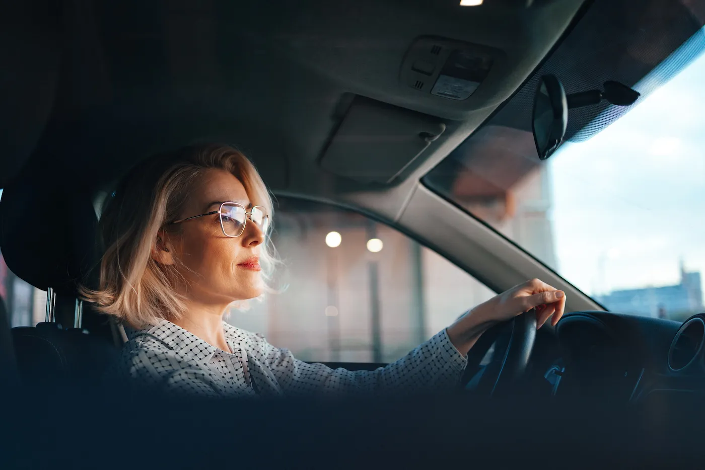 Smiling business woman traveling with her car around the city.