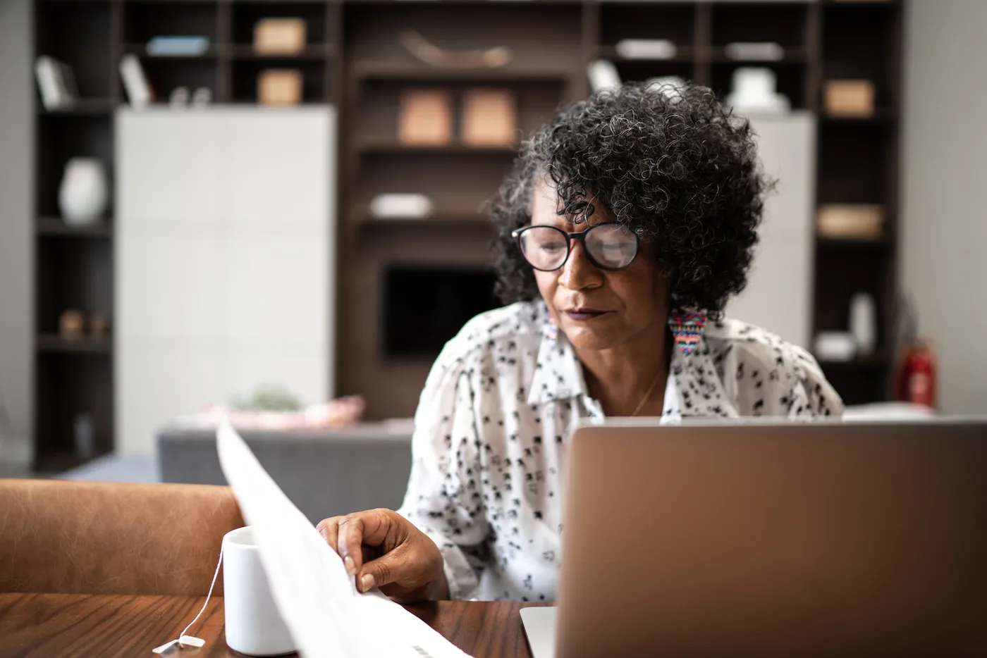 Senior woman working on retirement account finances in her home.