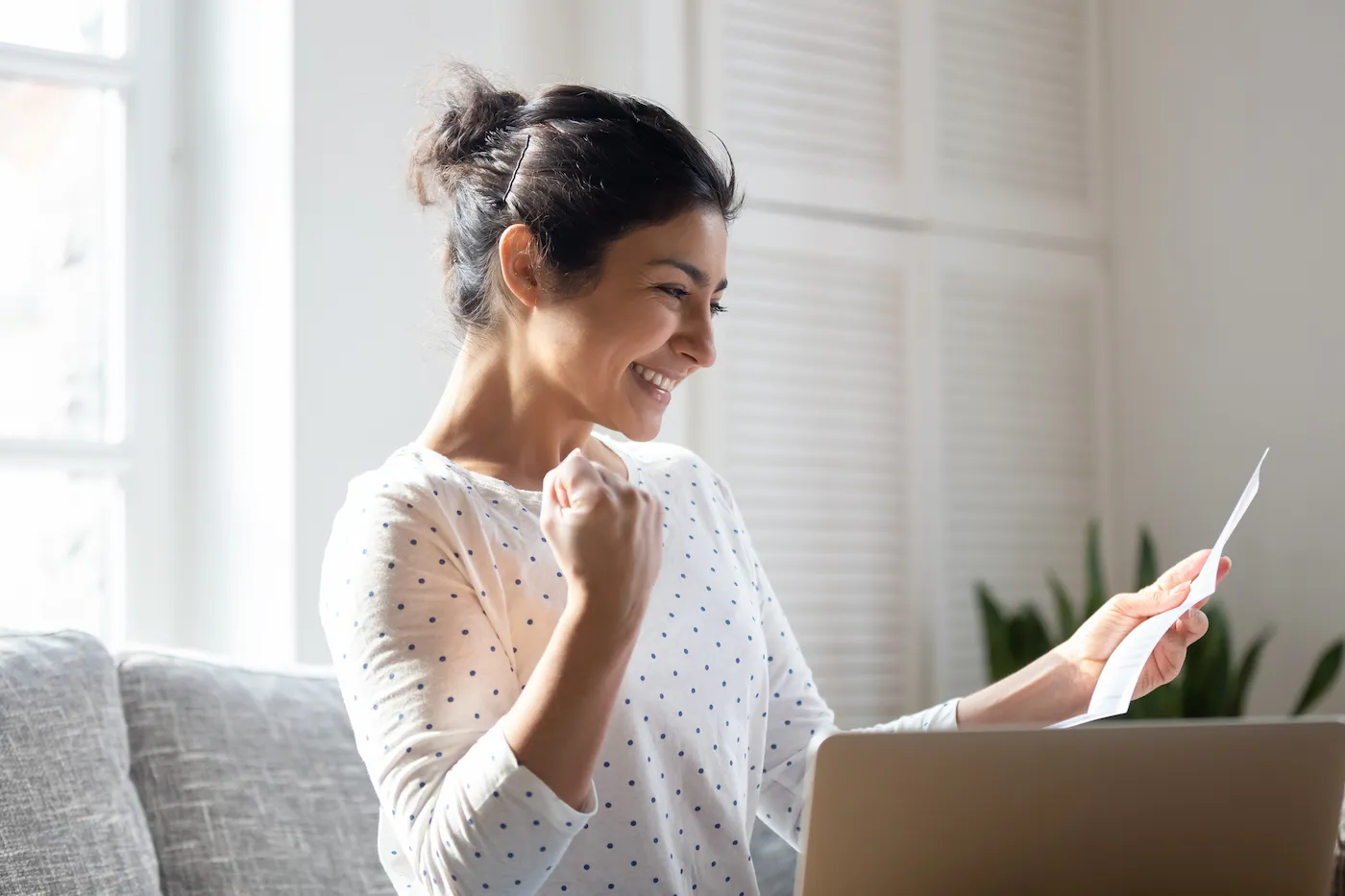 Happy woman reading a letter with a firm offer of credit.