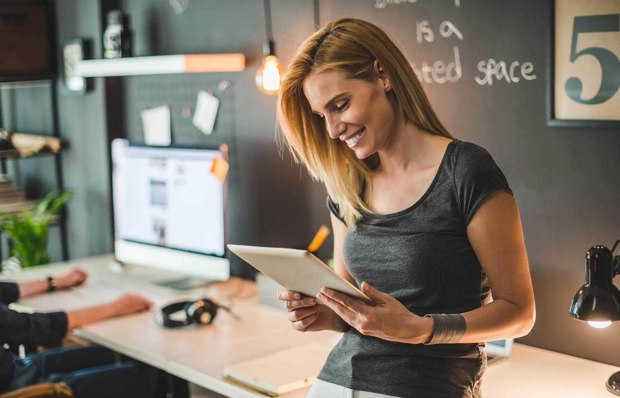 Woman smiles while looking at table at her work office.