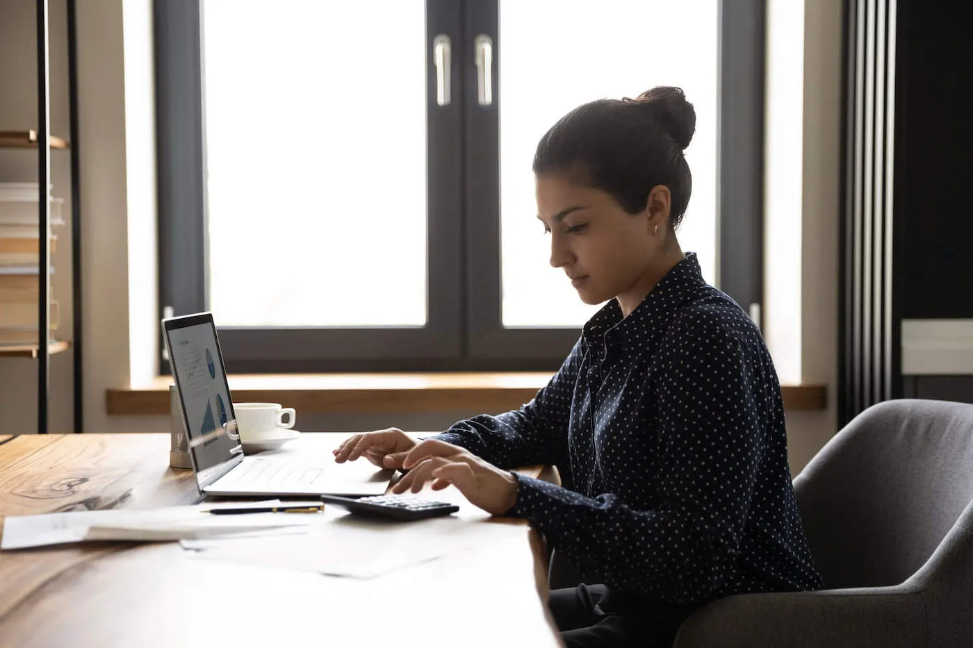 Woman seated at desk going over debt and finances.