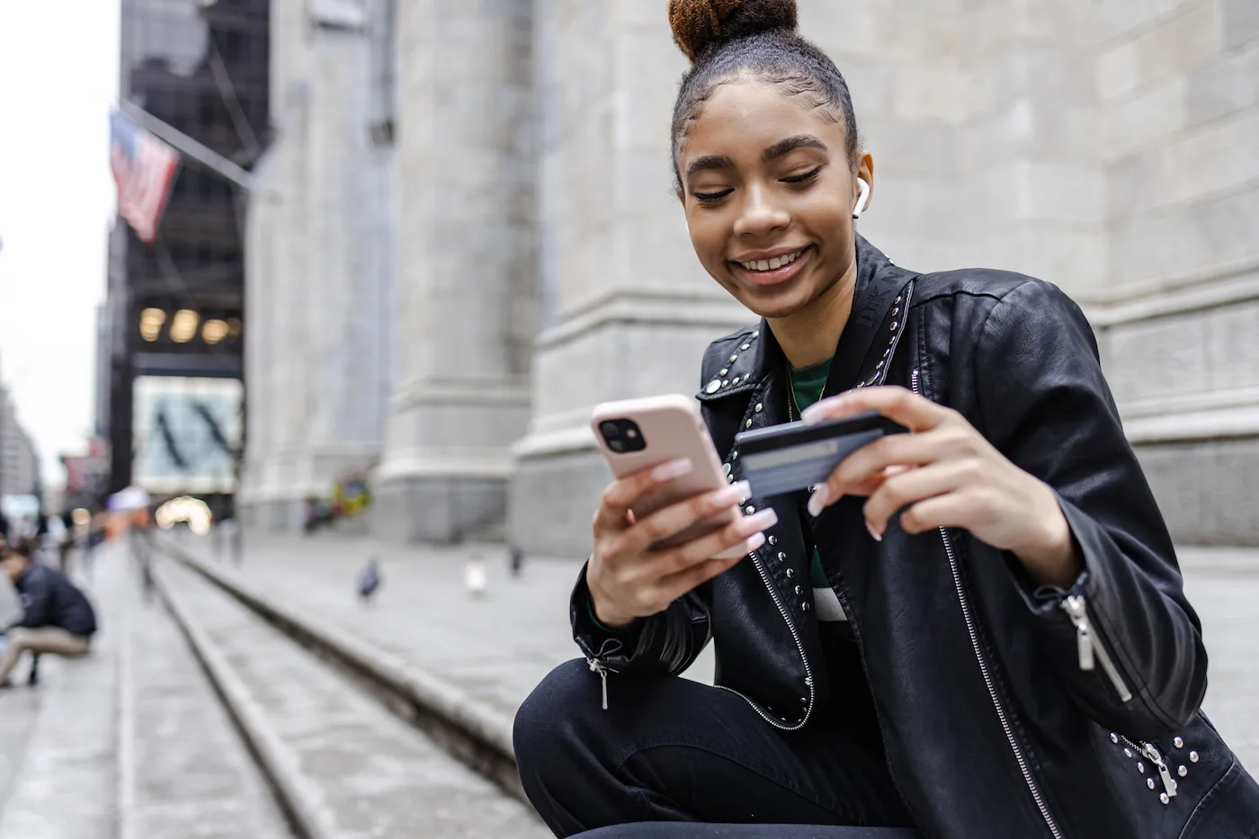 Young woman using credit card and mobile phone to shop online, using purchase protection