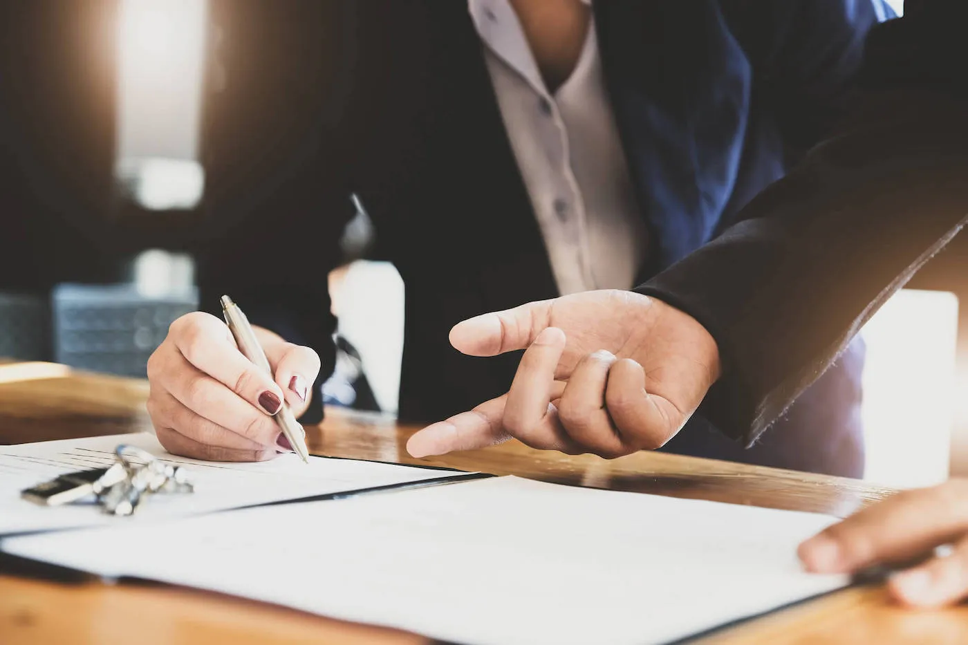 Woman signing a contract upon purchase of house.