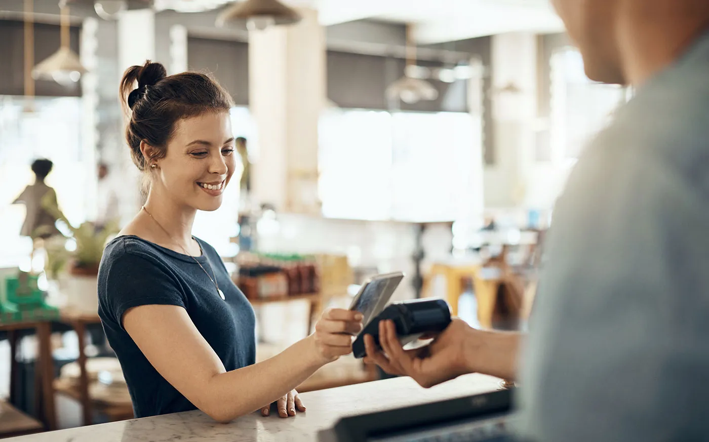 A woman using buy now, pay later to check out at a store.