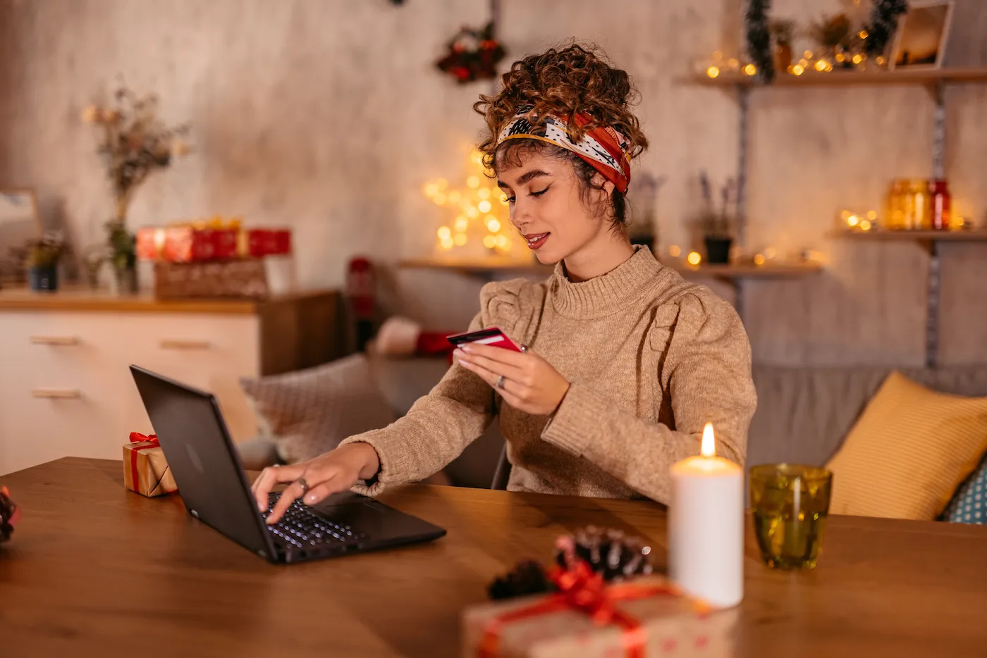 Woman using gift card on her laptop sitting at a table.