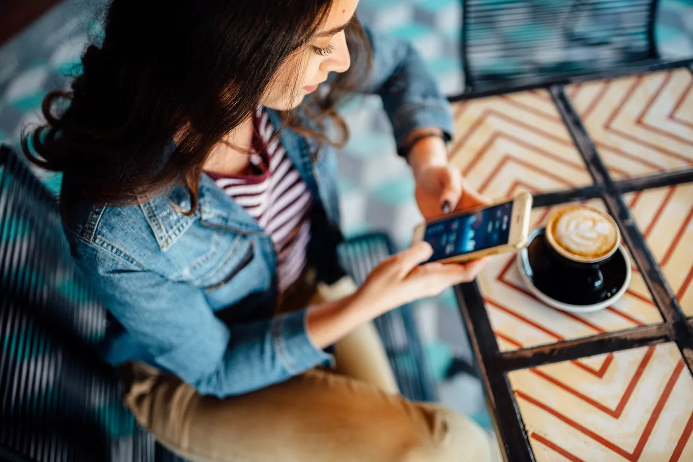 Woman using investment app in coffee shop