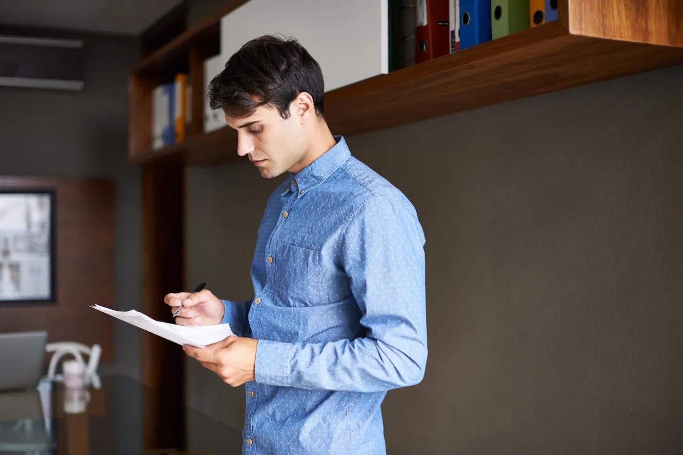 Shot of a man writing and reviewing a financial hardship letter.