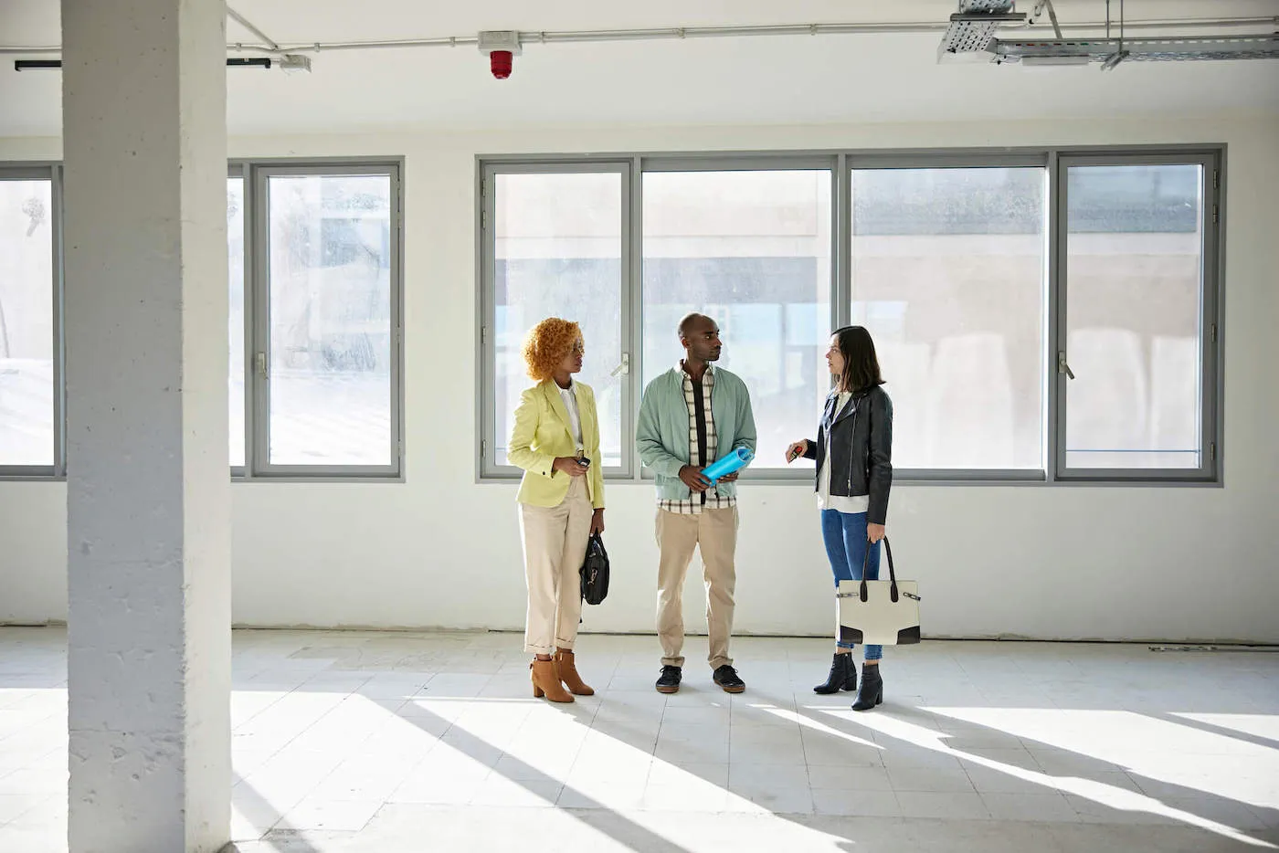 Young african american man and woman couple discussing property with broker.