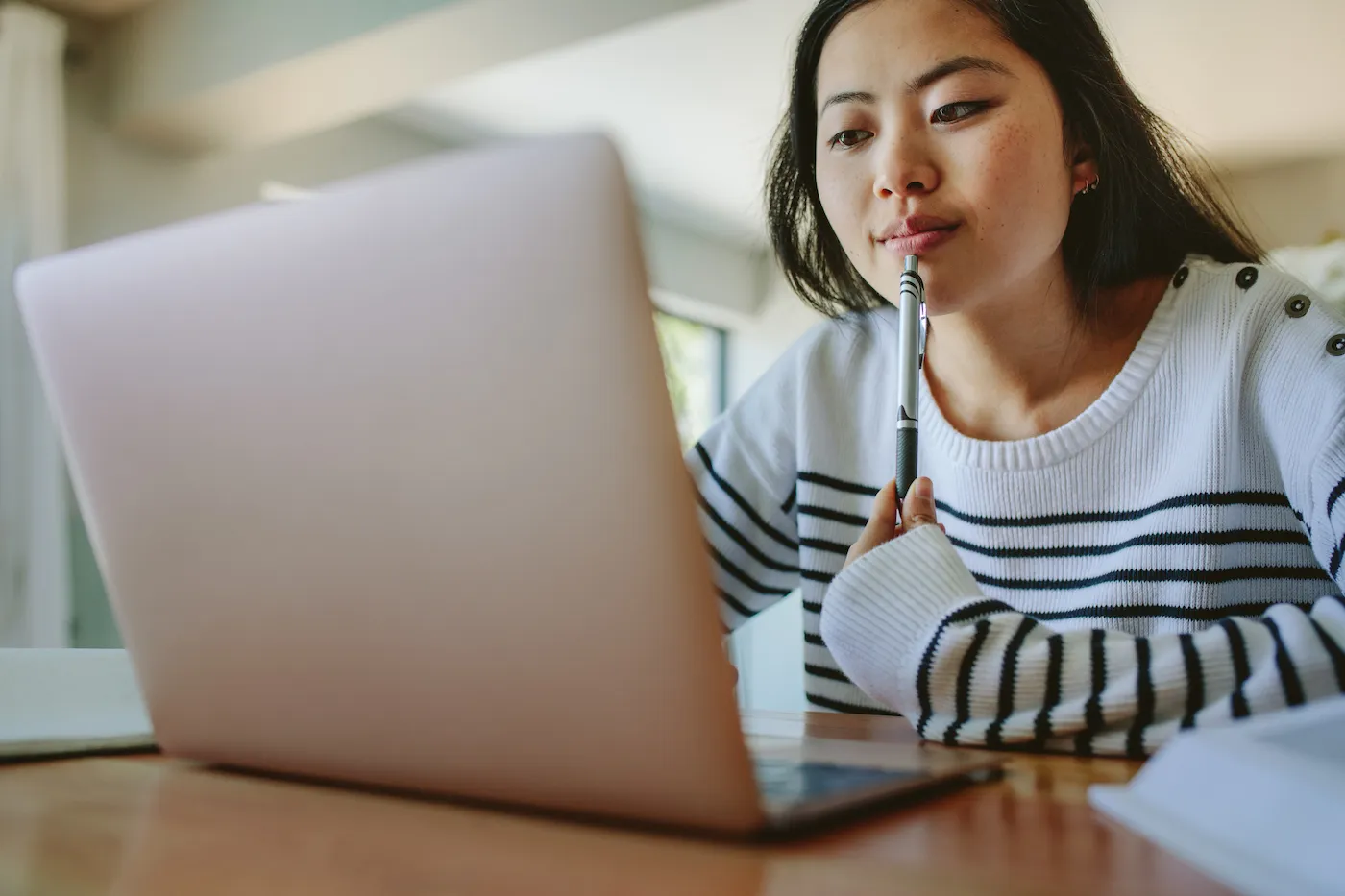 Young college girl checkingg her student loan balance on her laptop