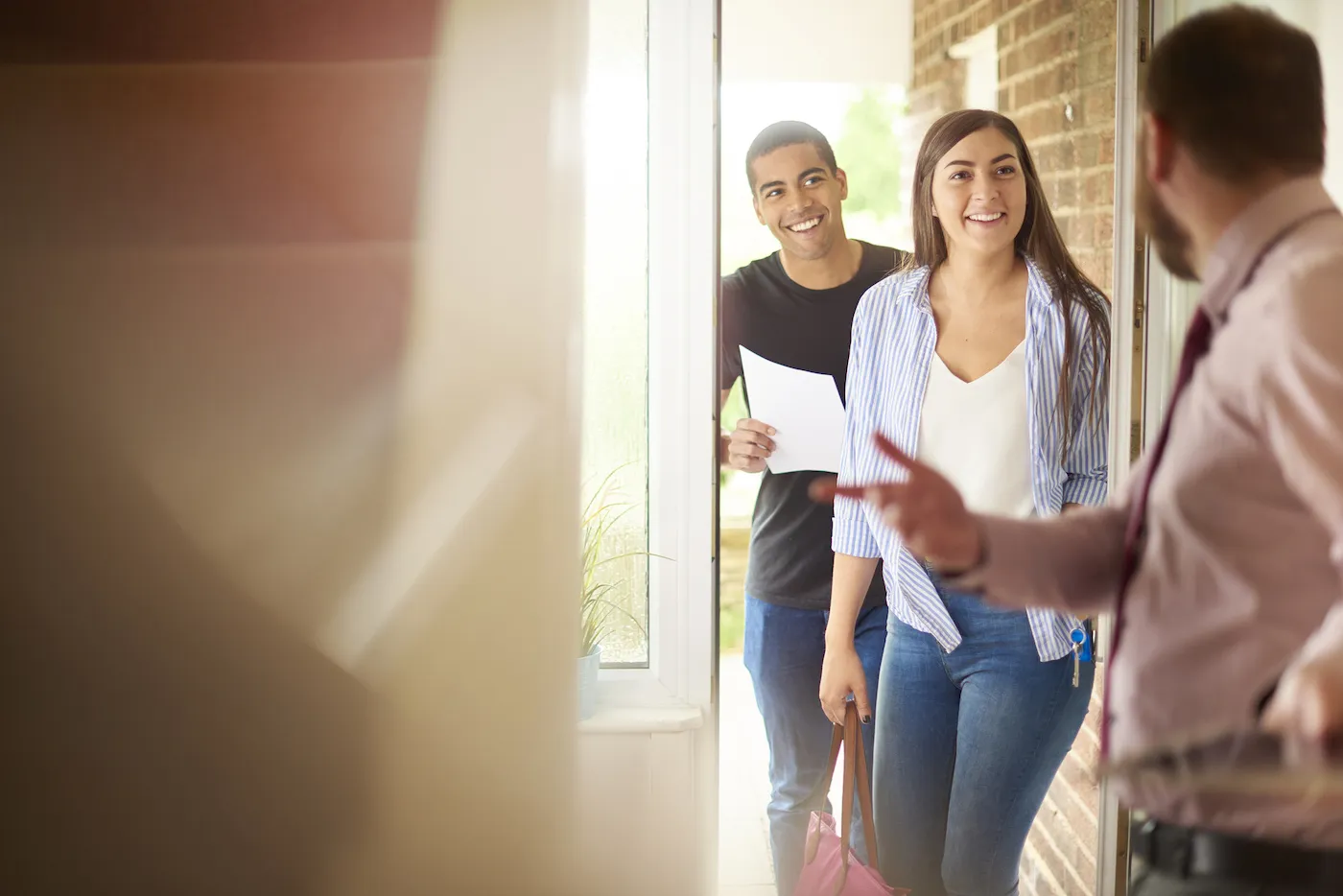 Young couple at open house holding a rental resume.