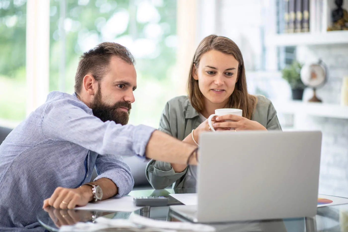 Young couple working together at home to create a financial budget.