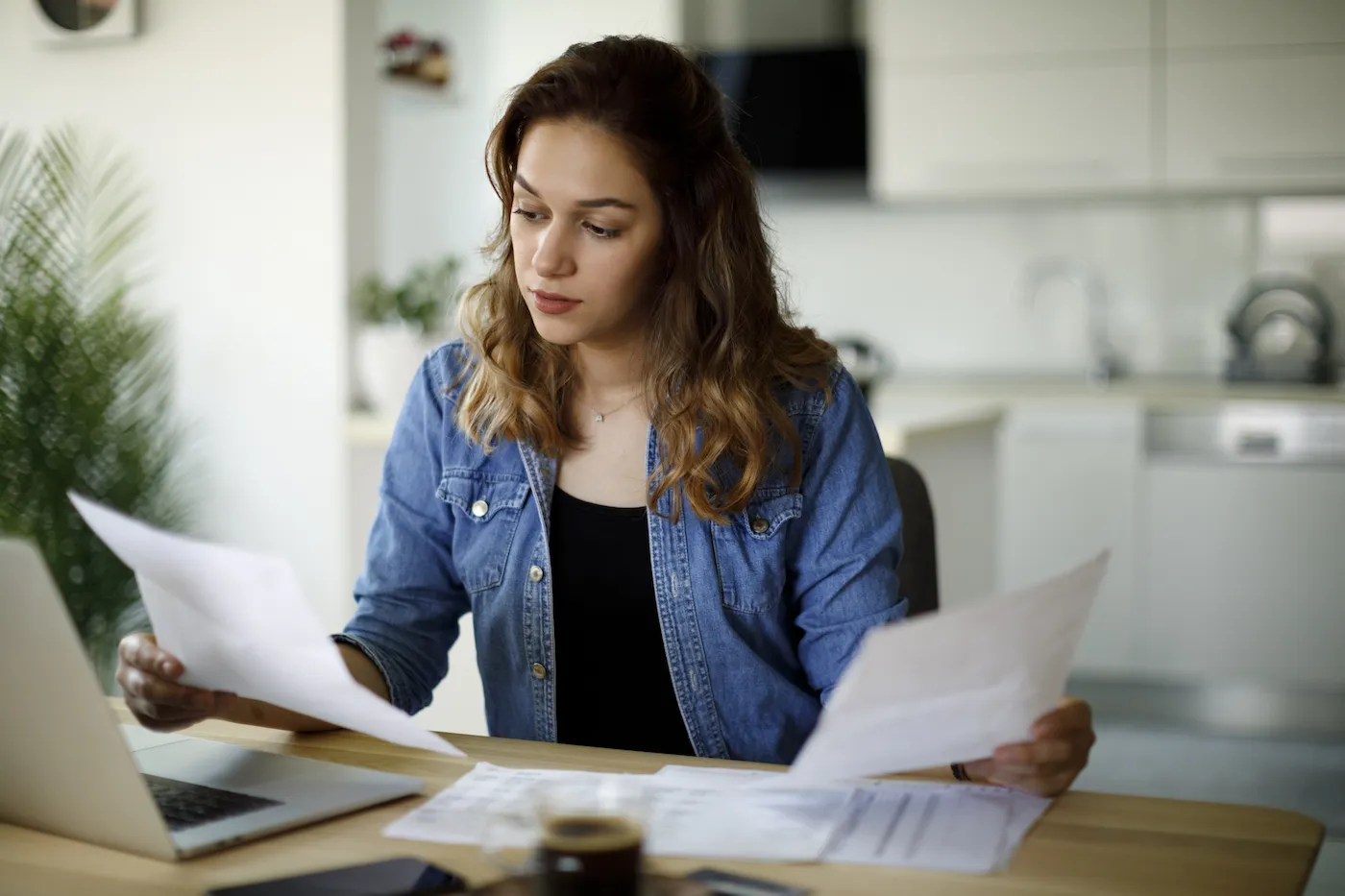 young woman comparing papers at table