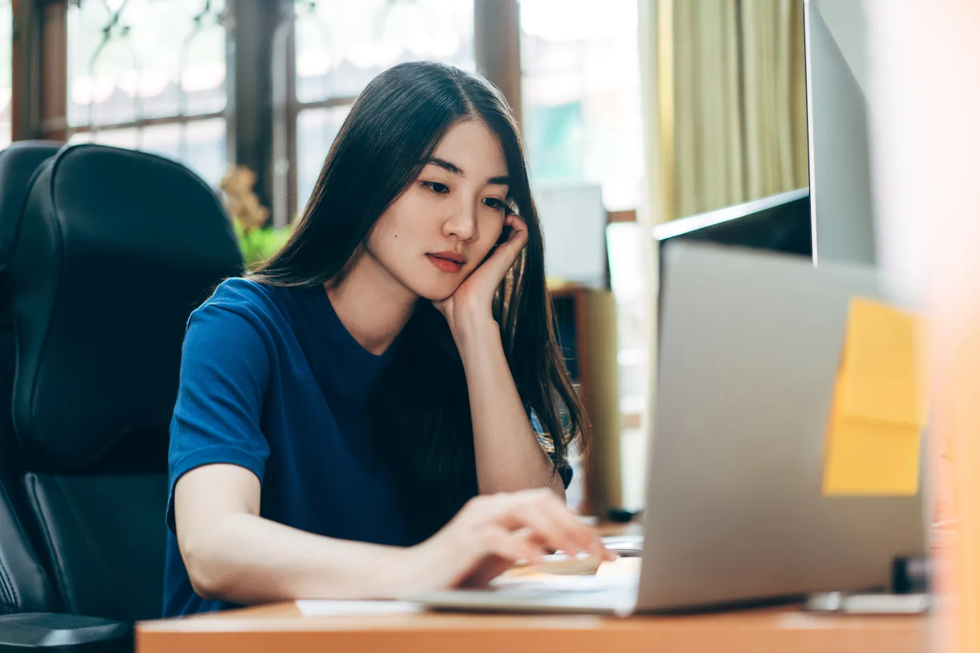 Young woman on her laptop filing taxes for the first time