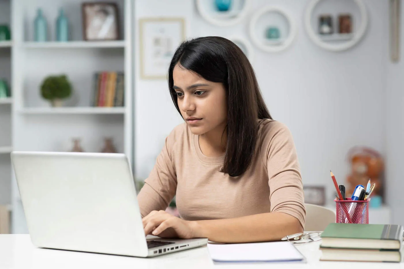 Young woman on laptop researching difference between sipc and fdic.