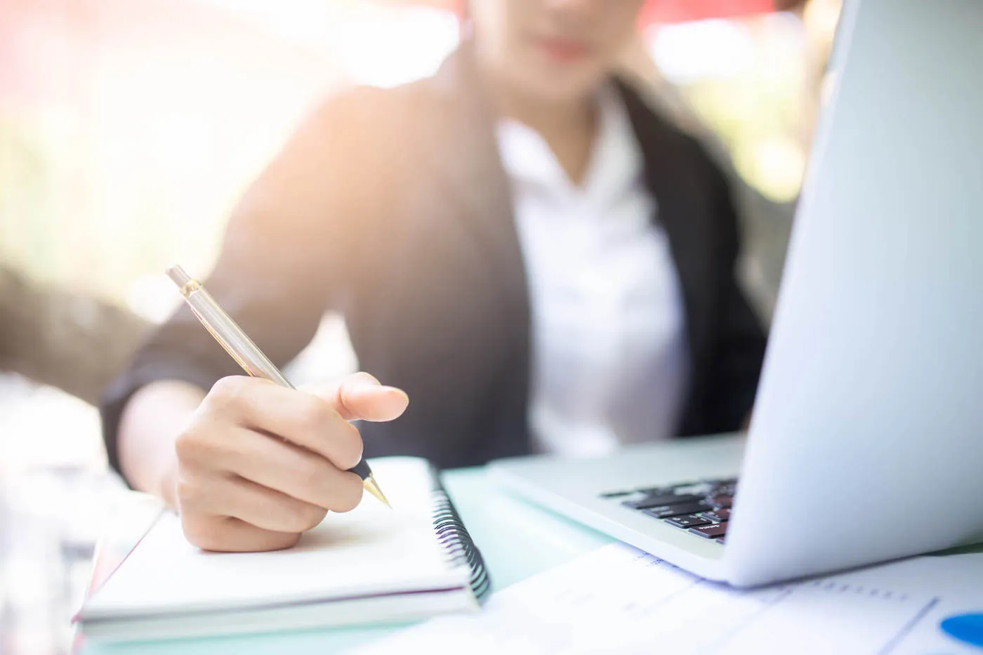 Young woman writing on notepad financial skills to master.