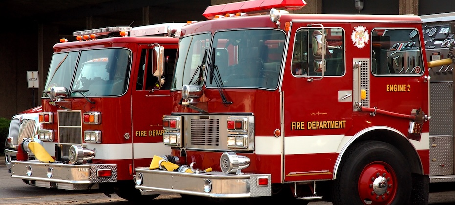 Two fire trucks parked outside of station