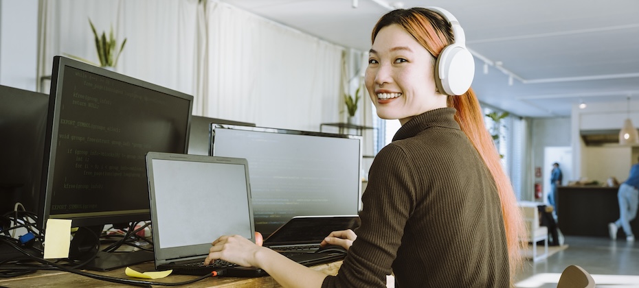 Portrait of smiling female programmer working on laptop in office