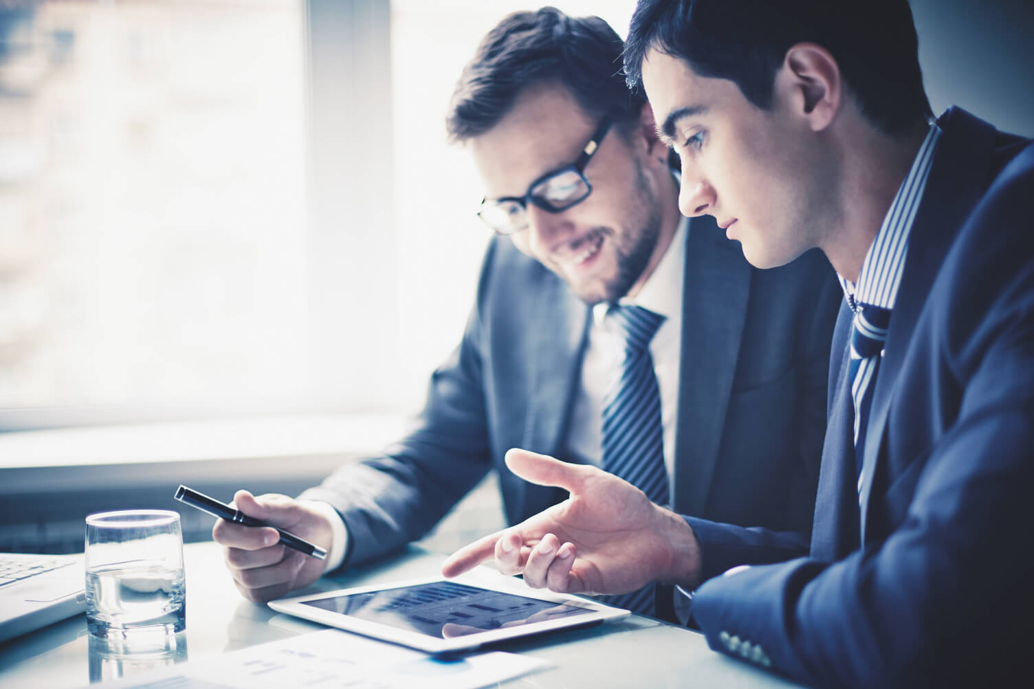 Example image of brand lifestyle photography with two businessmen looking down at a tablet