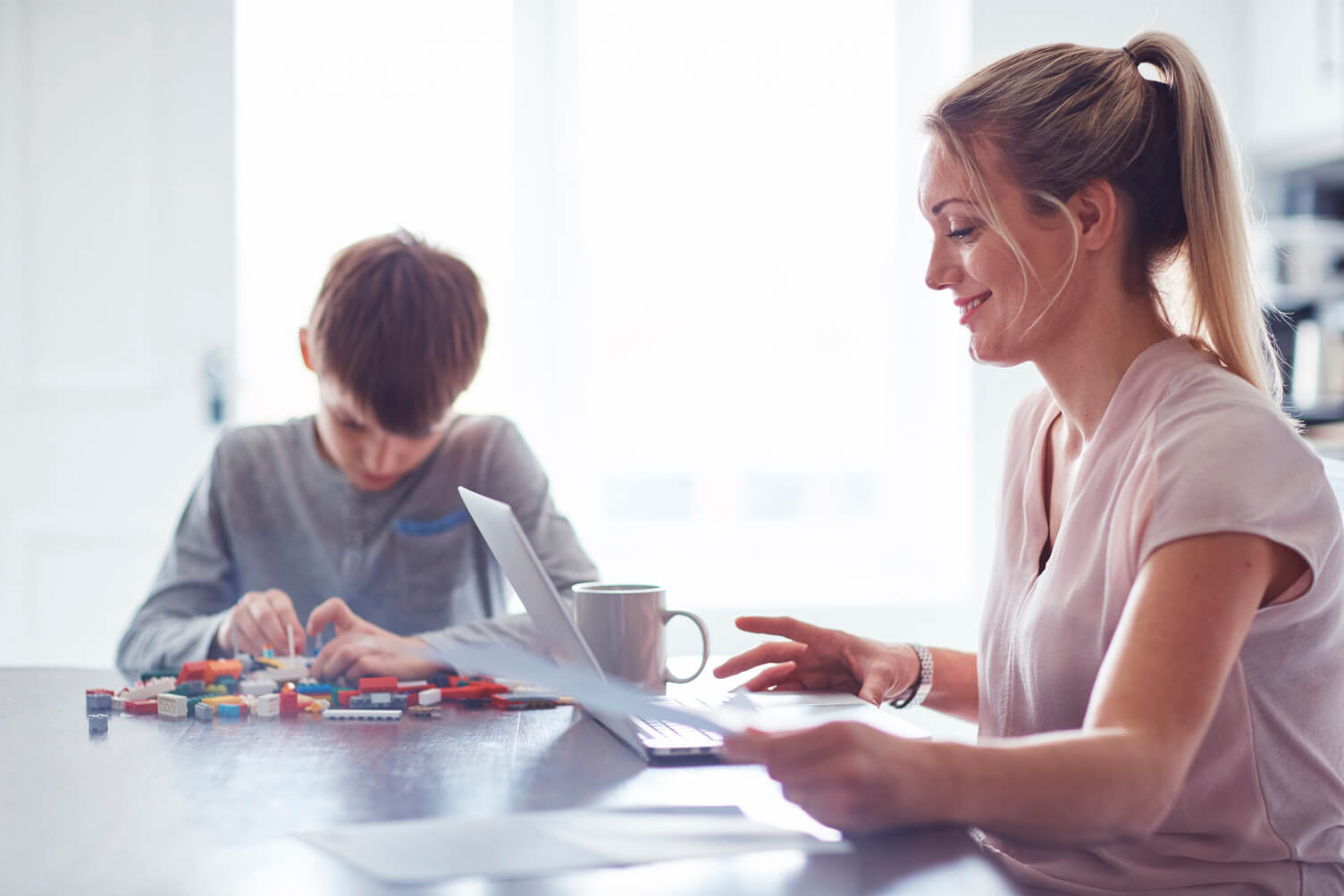 Example image of uncluttered background with a woman and chiild working on kitchen countertop with bright airy window behind them