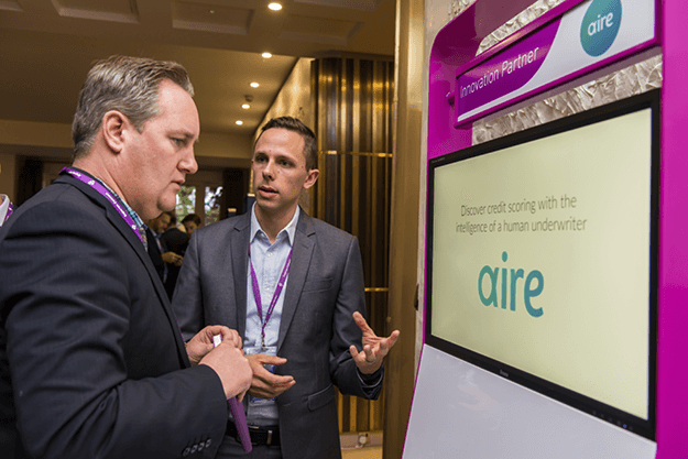 Two males talking in front of a bespoke demo pod