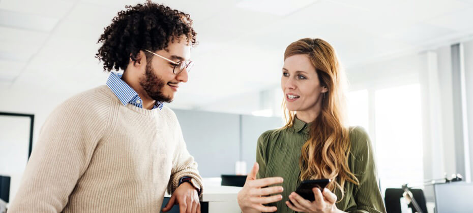 man and woman looking at mobile device