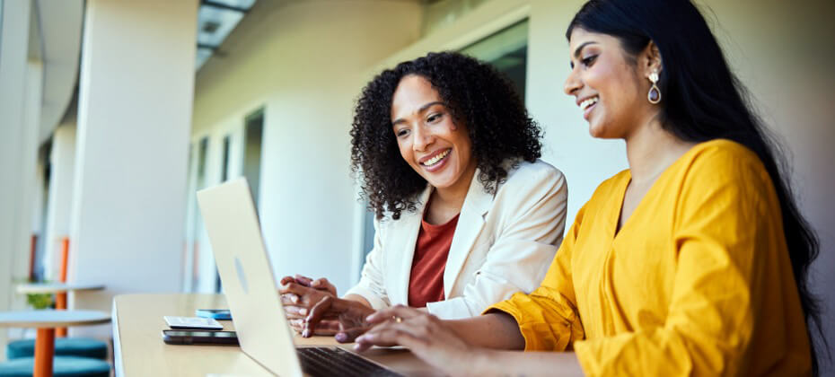 two women looking at computer smiling